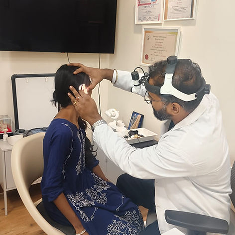Dr. Nikhilesh examining patient ear in private consultation chamber